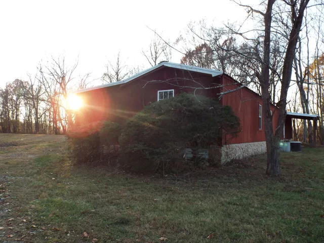 a view of a small yard in front of a house with large trees