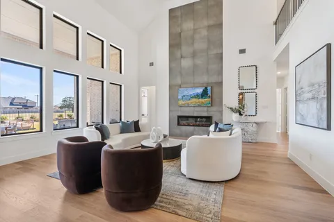 a living room with furniture a fireplace and a large window
