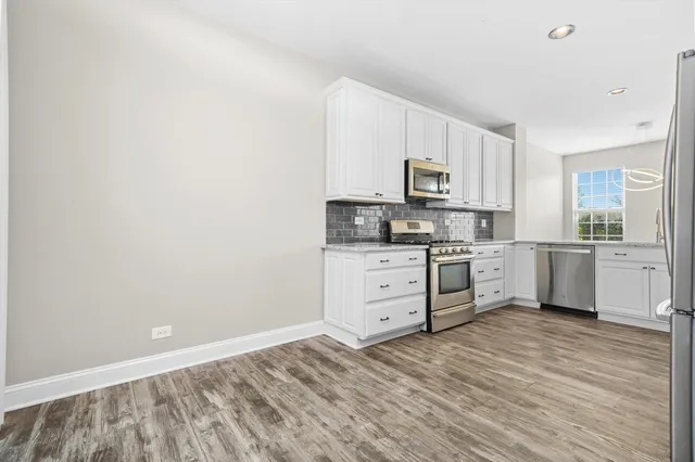 a kitchen with granite countertop white cabinets and white appliances