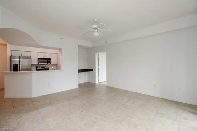 an empty room with closet and a chandelier fan