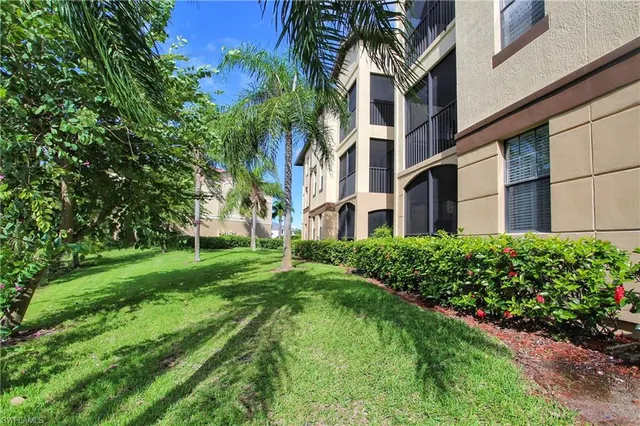 a view of a big building with big yard and large trees