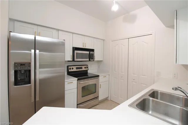 a kitchen with sink cabinets and stainless steel appliances