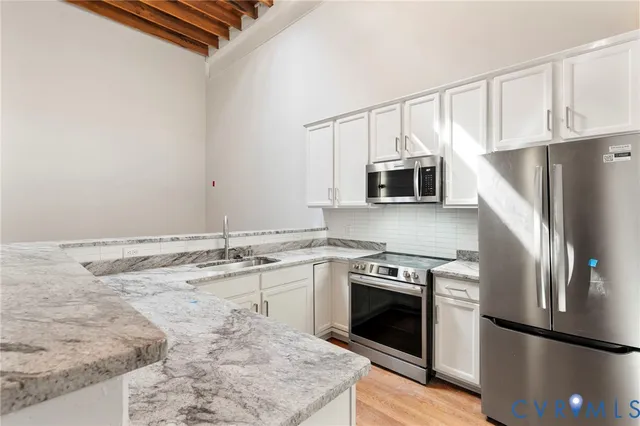 a kitchen with granite countertop a stove sink and refrigerator