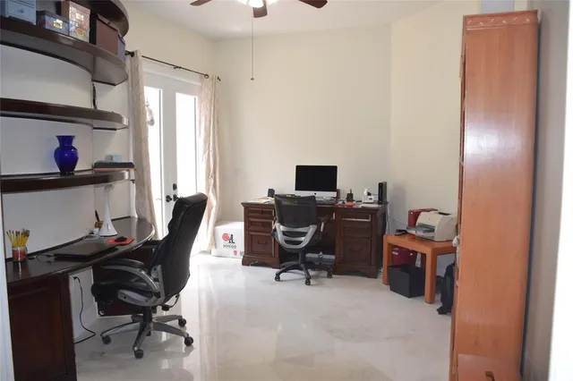 a view of a workspace with furniture and a window