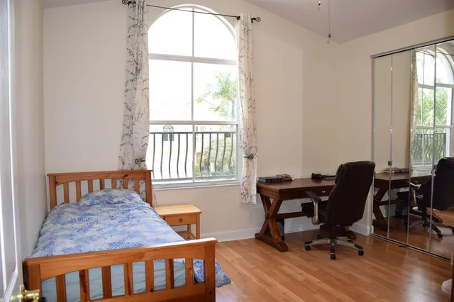 a bedroom with a bed and large windows