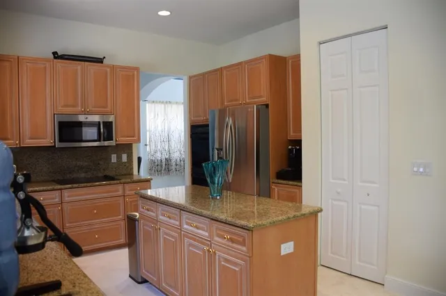 a kitchen with stainless steel appliances granite countertop a refrigerator and a stove top oven