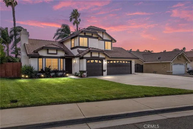 a front view of a house with a garden and yard