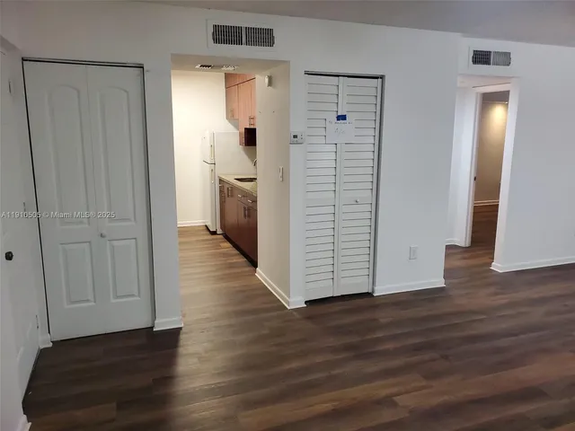 a view of a hallway with wooden floor and closet