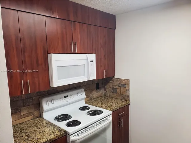 a stove top oven sitting inside of a kitchen