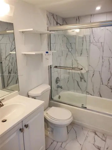 a bathroom with a toilet sink and shower
