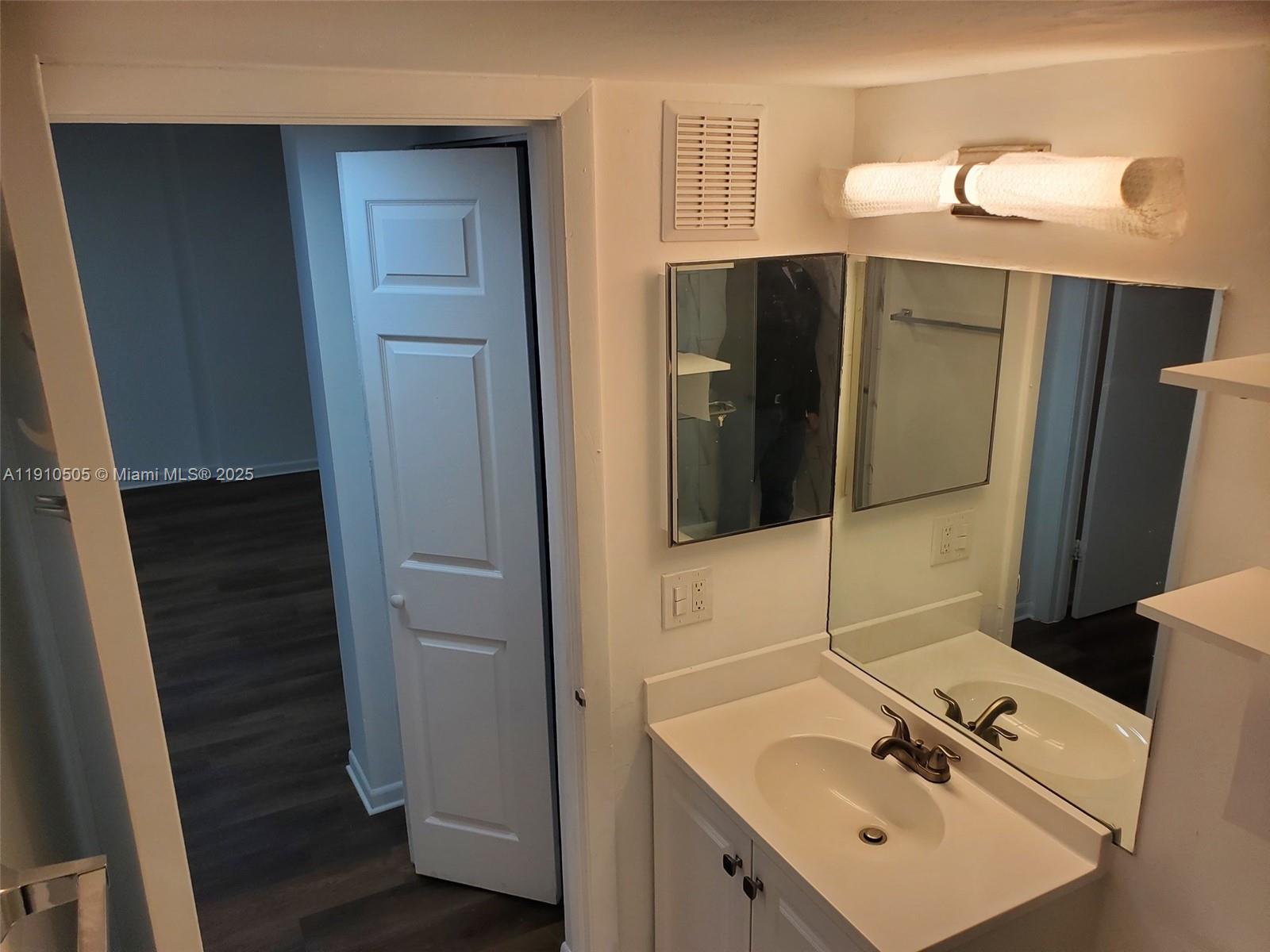 8260 Southwest 210th Street, Unit 217 Cutler Bay, FL 33189 - Photo 10 of 19 a bathroom with a sink vanity and mirror