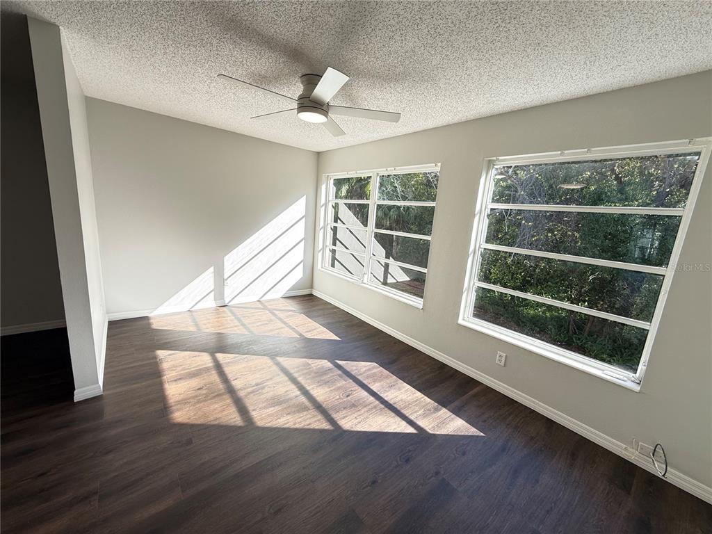 2391 Sumatran Way, Unit 63 Clearwater, FL 33763 - Photo 14 of 15 an empty room with wooden floor and windows