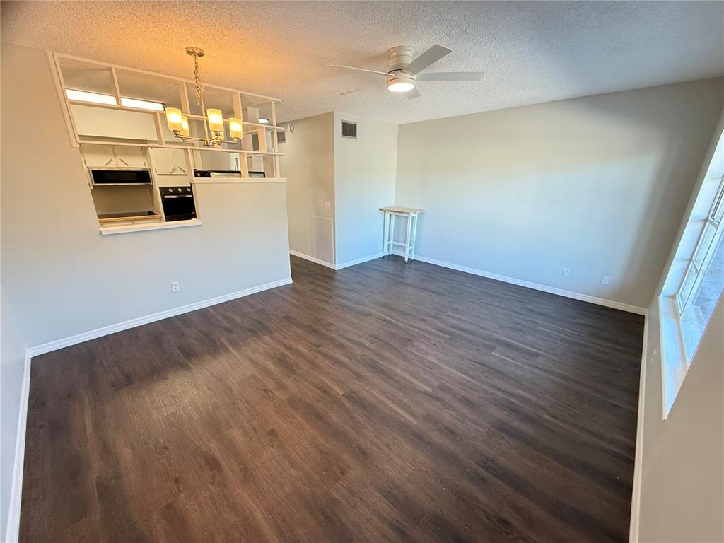 2391 Sumatran Way, Unit 63 Clearwater, FL 33763 - Photo 2 of 15 a kitchen with kitchen island a sink wooden floor and window
