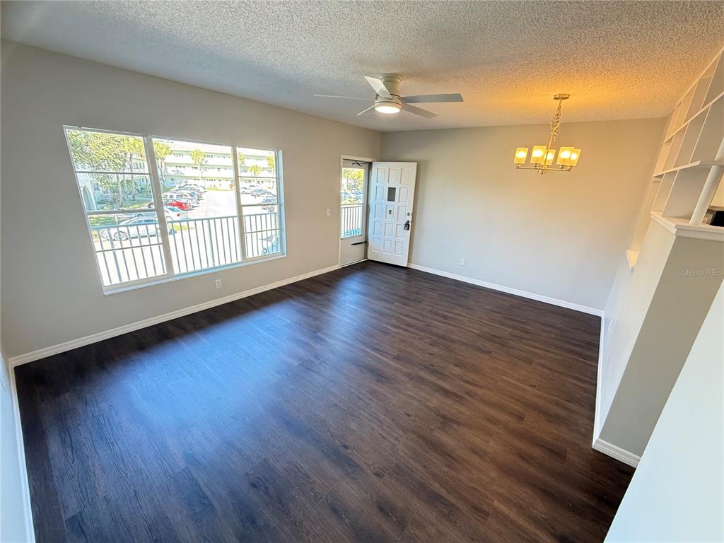2391 Sumatran Way, Unit 63 Clearwater, FL 33763 - Photo 3 of 15 an empty room with wooden floor and windows