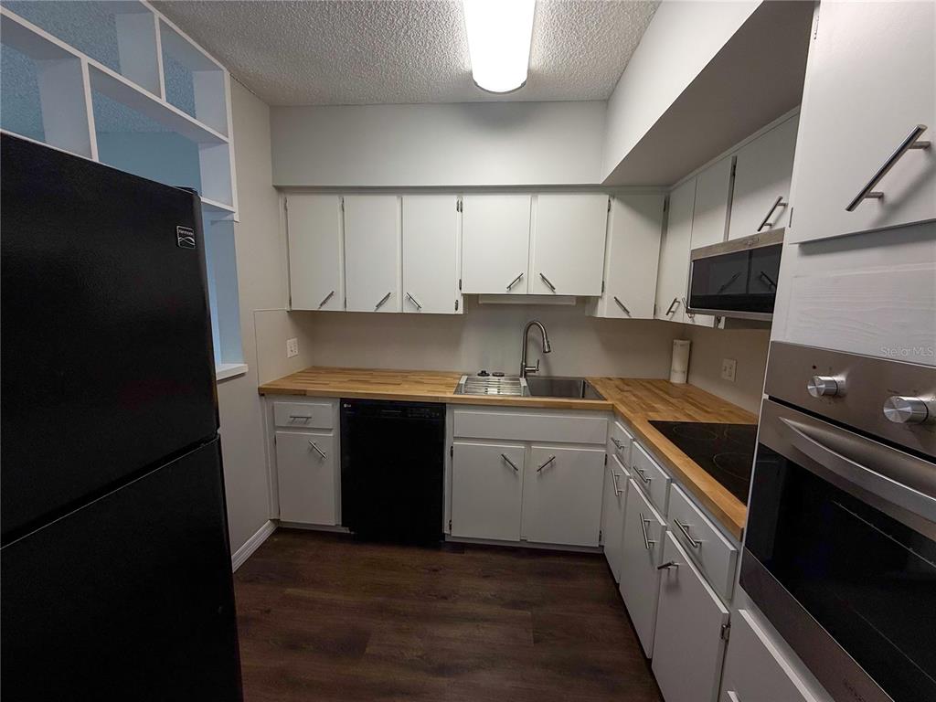 2391 Sumatran Way, Unit 63 Clearwater, FL 33763 - Photo 6 of 15 a kitchen with stainless steel appliances granite countertop a refrigerator and a stove top oven