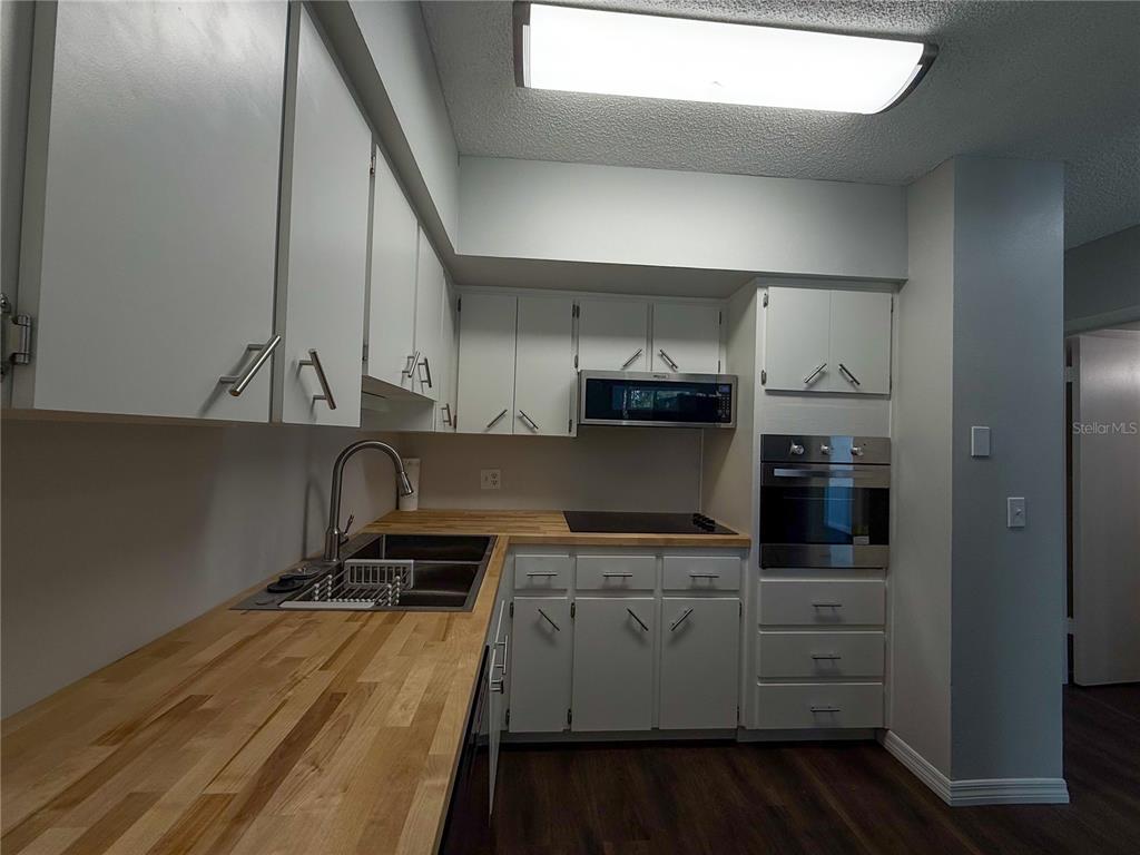 2391 Sumatran Way, Unit 63 Clearwater, FL 33763 - Photo 7 of 15 a kitchen with stainless steel appliances a refrigerator a stove and white cabinets