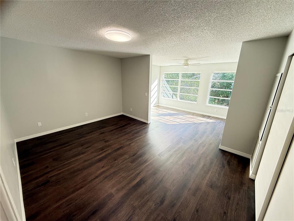 2391 Sumatran Way, Unit 63 Clearwater, FL 33763 - Photo 10 of 15 a view of an empty room with wooden floor and a window