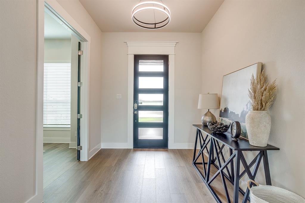 4511 Matador Rnch Road Waxahachie, TX 75165 - Photo 5 of 36 Entryway featuring wood-finish flooring, a contemporary ceiling light fixture, a dark-framed glass paneled door, and a glass-paneled interior door
