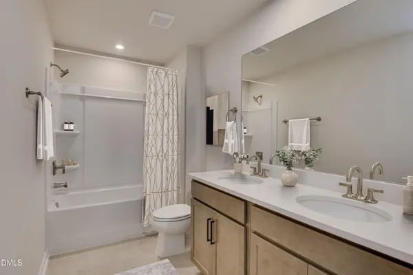a bathroom with a bathtub shower sink vanity and toilet