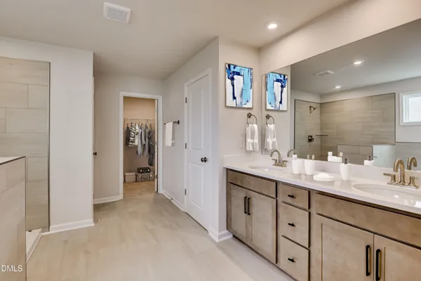a spacious bathroom with a double vanity sink mirror and shower