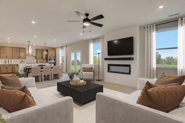 a living room with furniture kitchen view and a large window