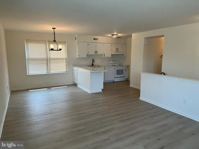 a kitchen with granite countertop a sink a stove and cabinets