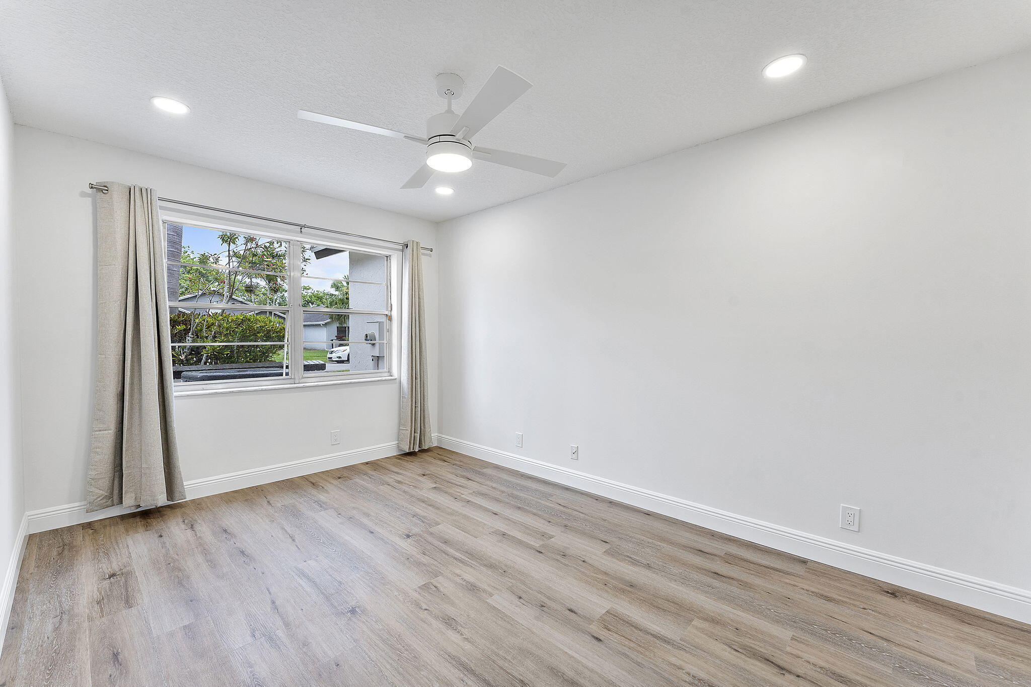 9180 Pine Springs Drive Boca Raton, FL 33428 - Photo 21 of 29 an empty room with wooden floor and windows
