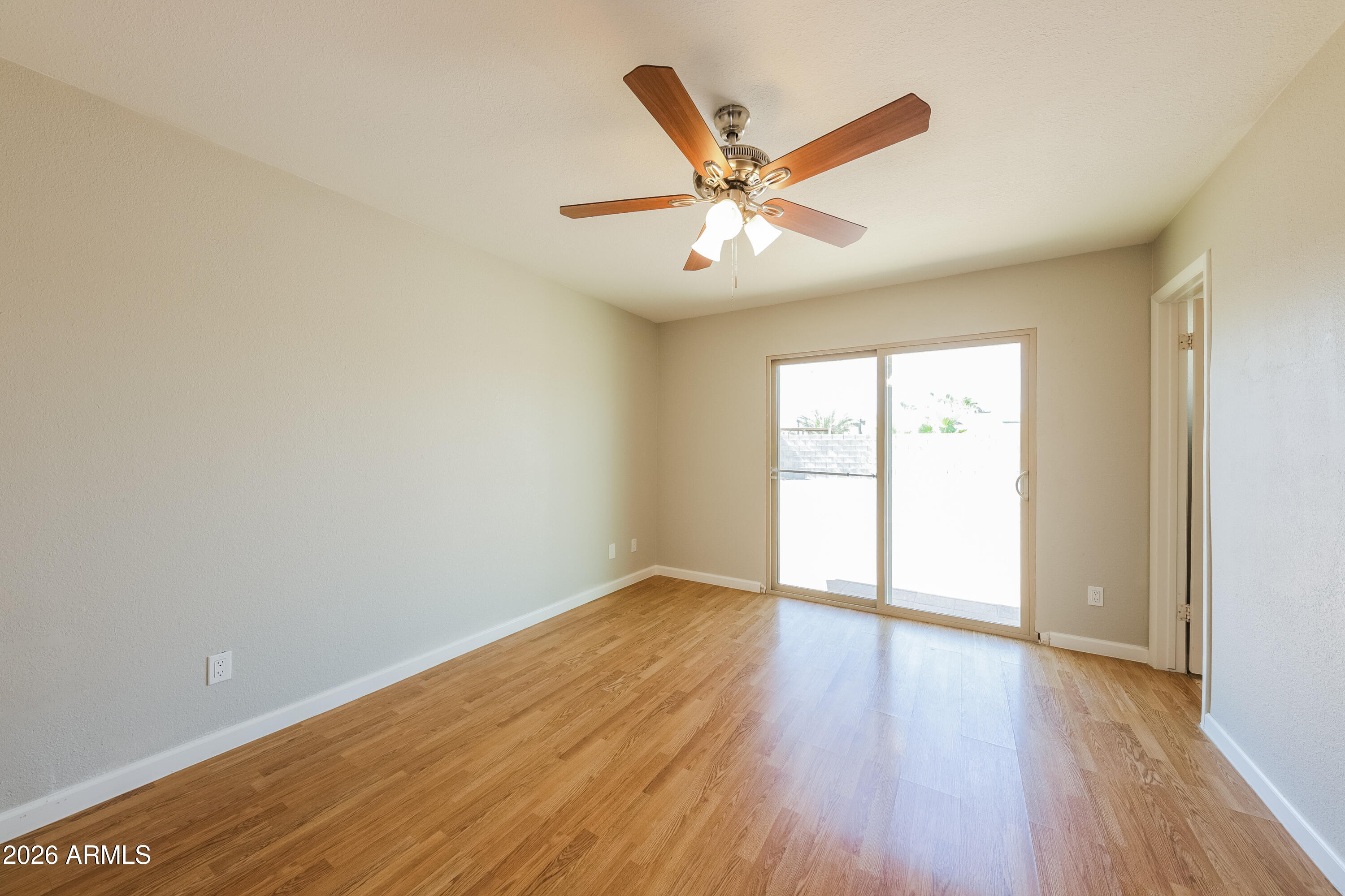 2501 East Villa Rita Drive Phoenix, AZ 85032 - Photo 14 of 15 an empty room with wooden floor fan and windows