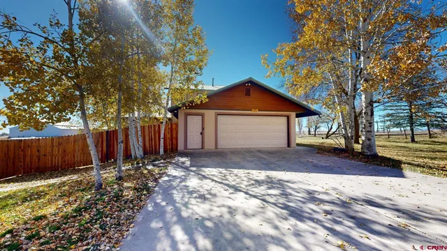 a front view of a house with a yard and tree