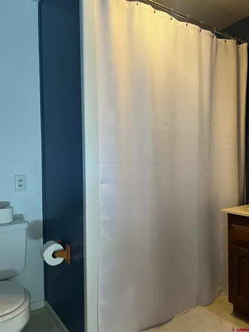 a bathroom with a toilet and a shower curtain