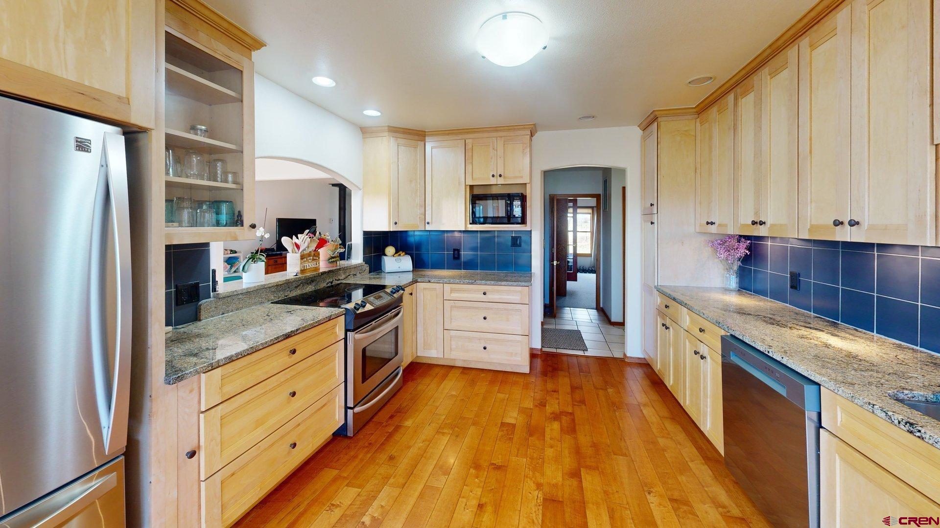 930 County Road 229 Durango, CO 81301 - Photo 20 of 32 a kitchen with stainless steel appliances granite countertop a refrigerator a stove and a wooden cabinets