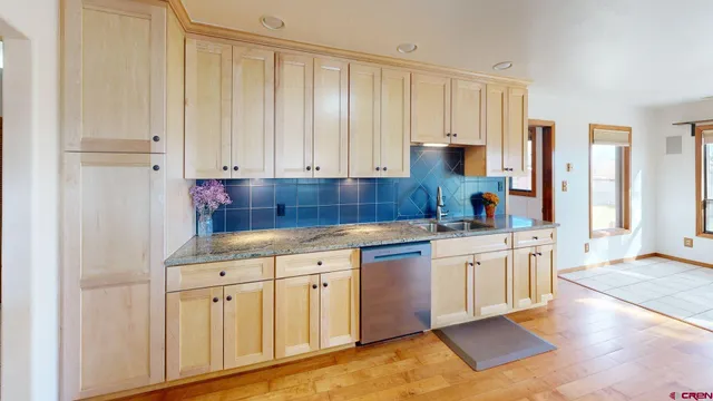 a kitchen with white cabinets and sink
