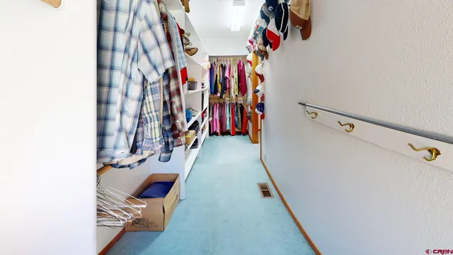 a view of walk in closet with clothes
