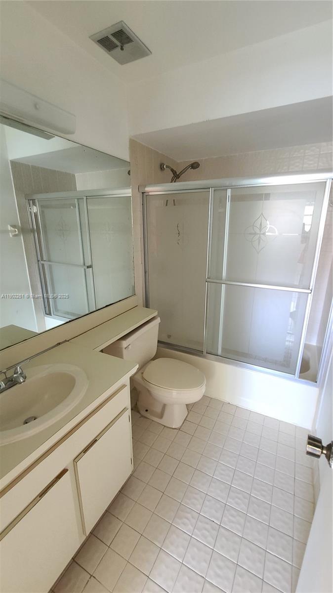 13458 Southwest 62nd Street, Unit Q105 Miami, FL 33183 - Photo 12 of 16 a bathroom with a sink a toilet and shower
