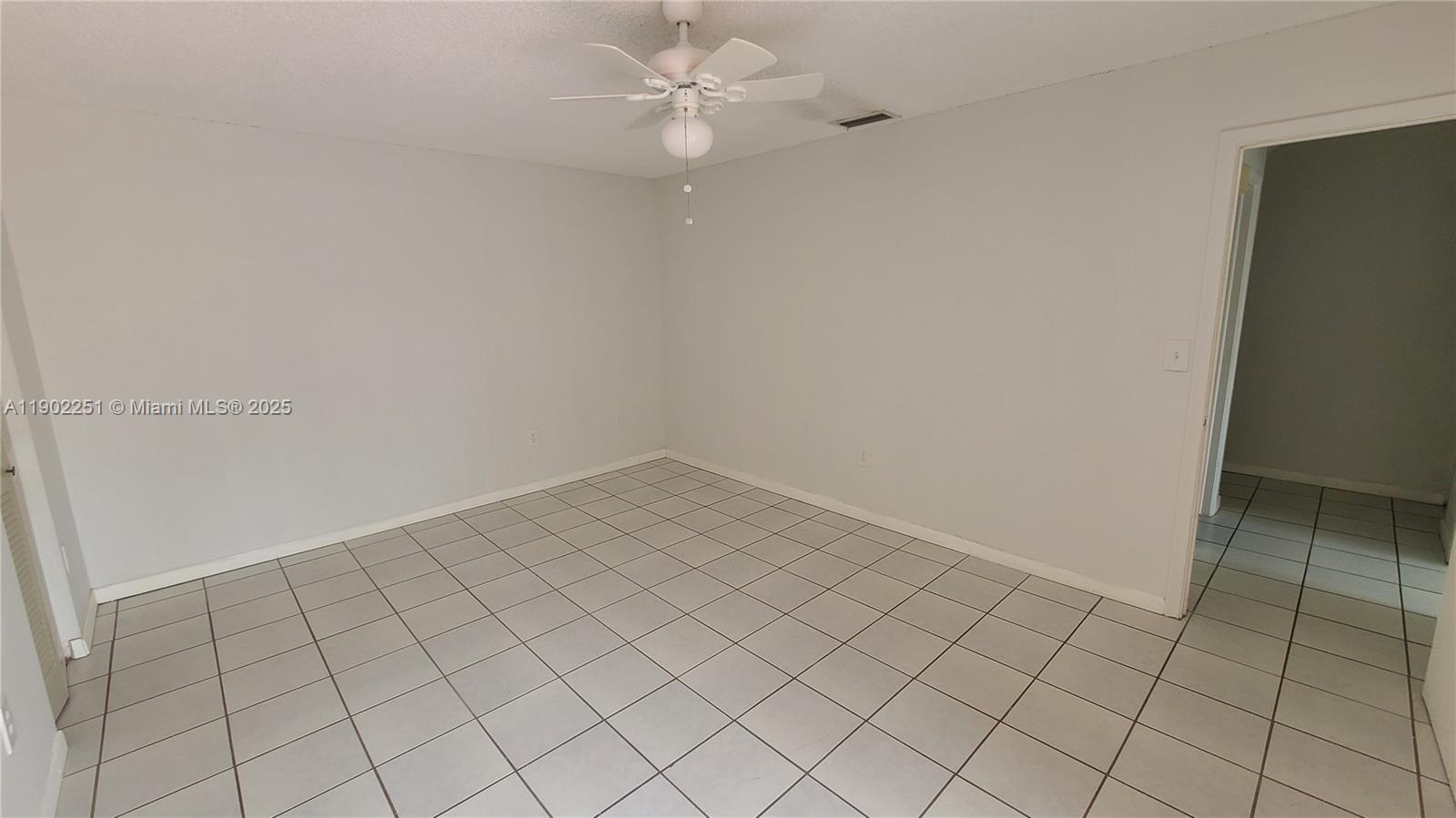 13458 Southwest 62nd Street, Unit Q105 Miami, FL 33183 - Photo 14 of 16 an empty room with white walls and ceiling fan