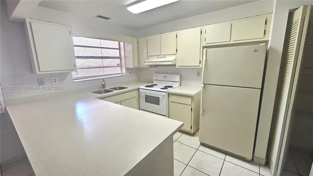 a white refrigerator freezer sitting inside of a kitchen