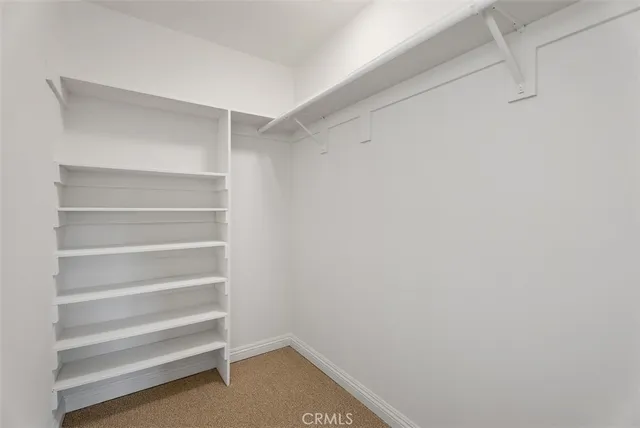 a view of walk in closet with empty racks