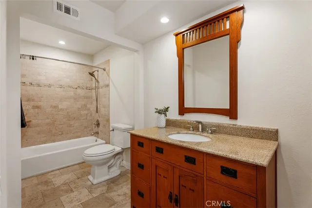 a bathroom with a granite countertop sink toilet and shower