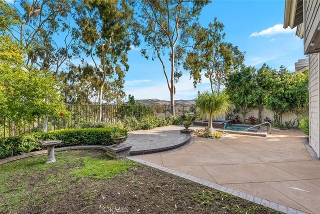 a backyard of a house with fountain table and chairs