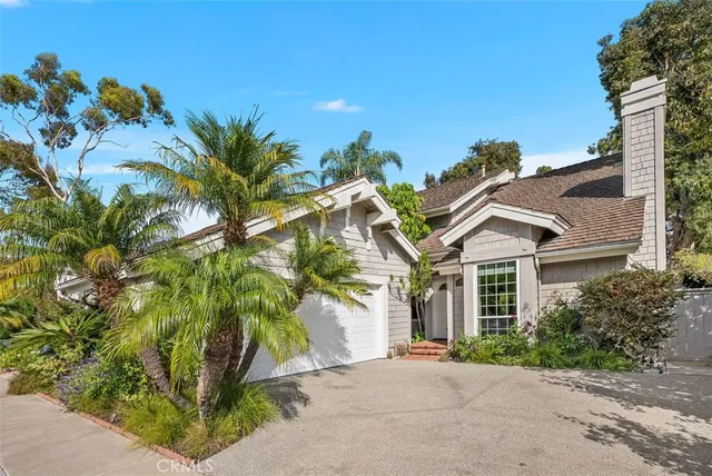 a view of a white house with a plants and iron fence