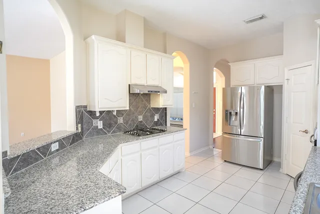 a kitchen with stainless steel appliances granite countertop a sink and a refrigerator