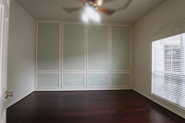 an empty room with wooden floor and window