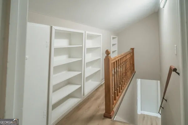 a view of a hallway with wooden floor and entryway