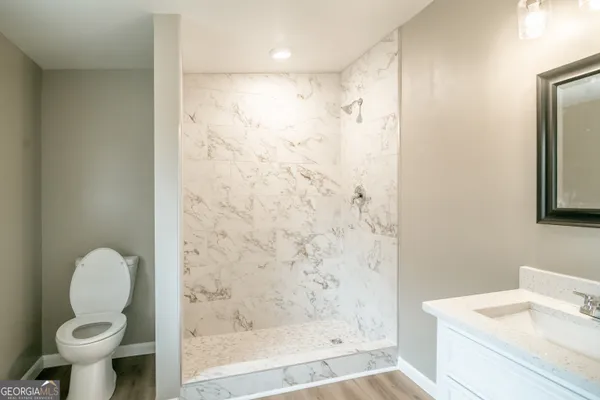 a bathroom with a shower a toilet and a sink