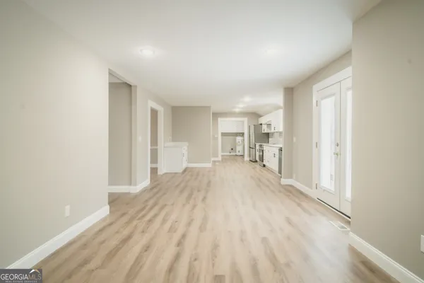 a view of empty room with wooden floor
