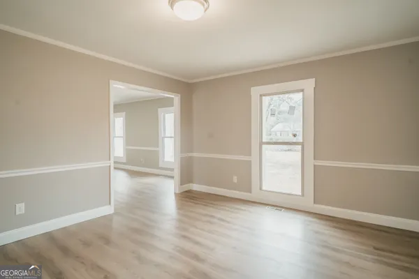 an empty room with wooden floor & closet and windows