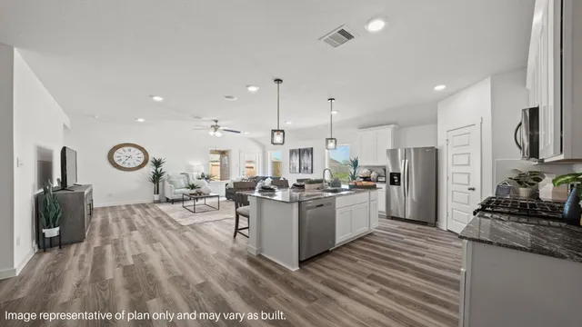 a kitchen with sink refrigerator and wooden floor
