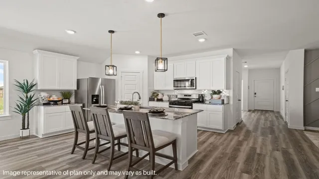 a kitchen with stainless steel appliances a dining table chairs stove and white cabinets