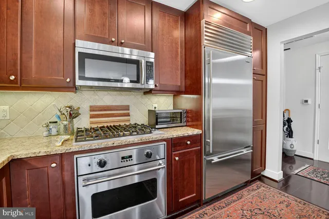 a kitchen with stainless steel appliances granite countertop a stove microwave and refrigerator