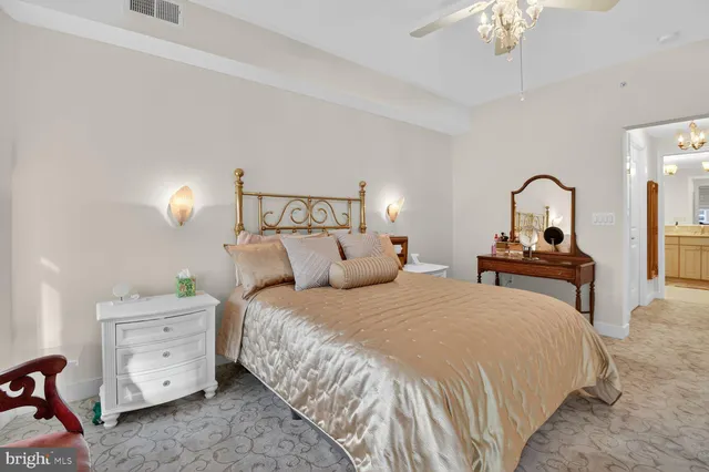a bedroom with a bed and a lamp on dresser